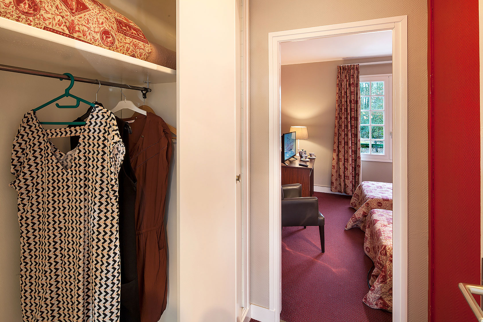 Intérieur de la chambre Cerise, avec vue sur le parc. Au premier plan, la penderie et à droite, la salle de bains.