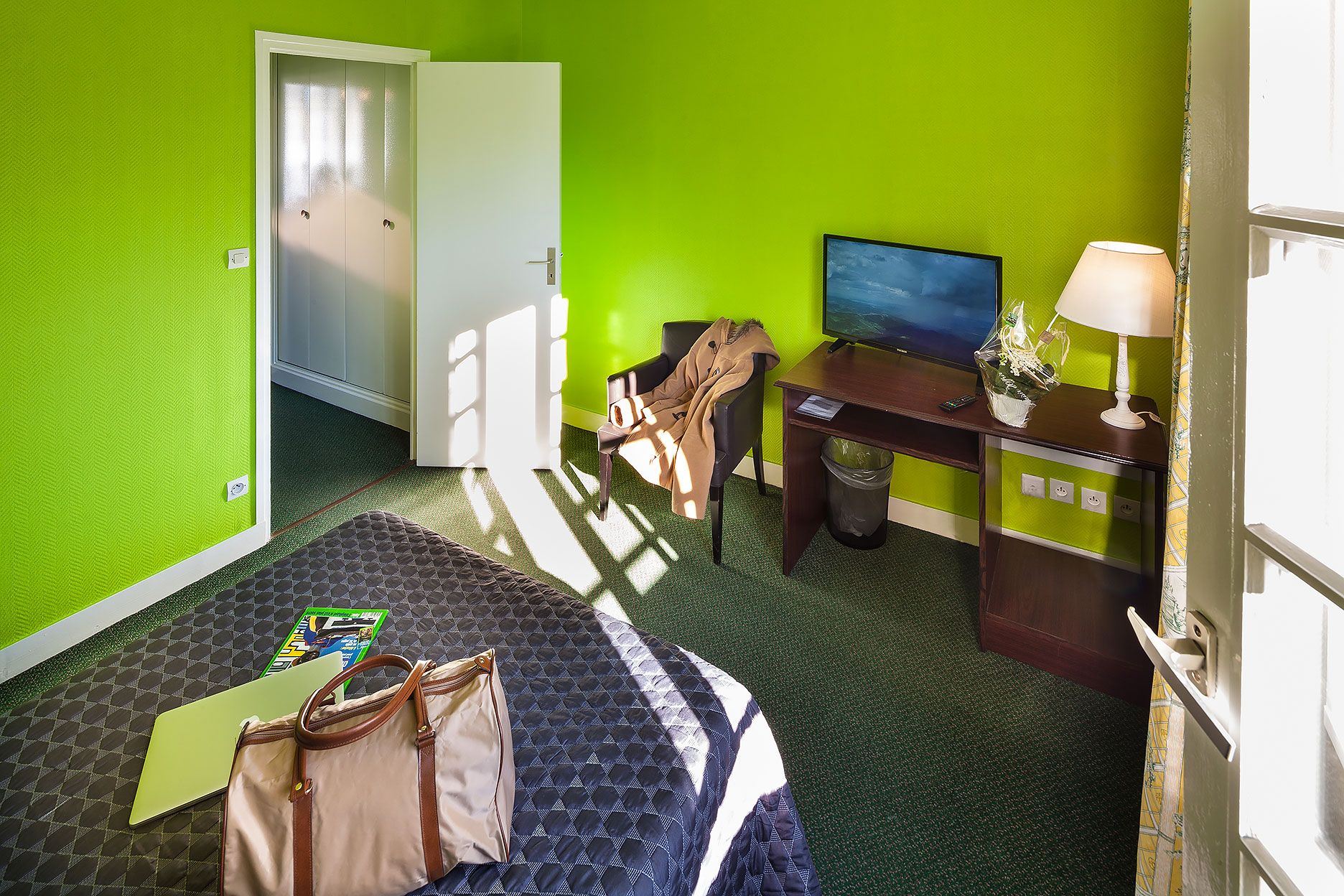 Intérieur de la chambre Granny, aménagée avec bureau, écran plat, salle de bains et toilette.